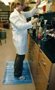 Scientist lab worker standing on top of Marbleized Blue Tile Top Anti-Fatigue Mats in a laboratory setting