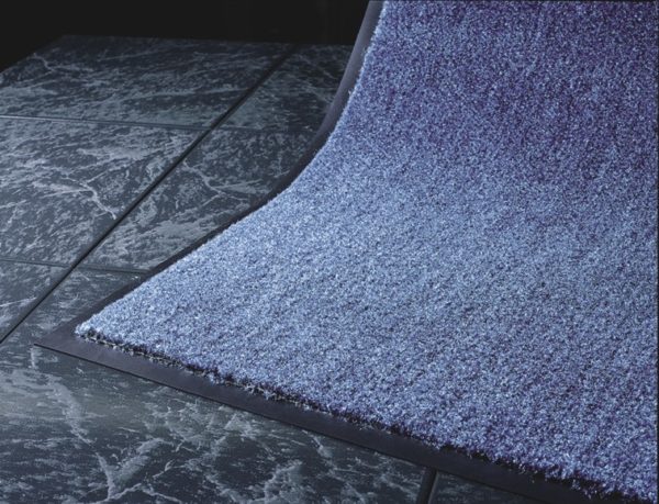 Corner Edge Detail picture of Olefin indoor floor mat showing black vinyl floor mat edging on a speckled blue carpet mat