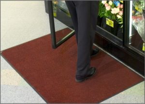 Man buying flowers while standing on a Tri Grip indoor floor mat at a florist