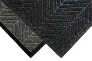Corner view of Waterhog Eco Elite floor mat with two floor mat edge options - Standard rubber and Fashion border edging