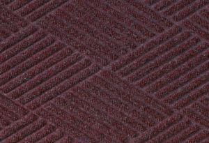 Close up surface view of Waterhog Eco Premier floor matting in a Maroon color