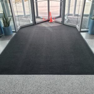 Custom Cut Berber entrance matting cut in around revolving door - Denver, CO